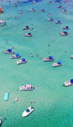 Aerial view of Crab Island sandbar in Destin Florida with boats and turquoise water