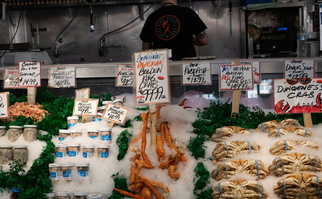 Fresh crab legs and whole crabs displayed on crushed ice at a fish market