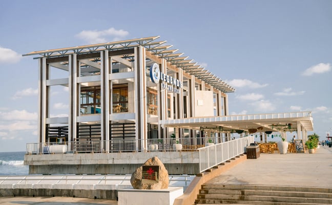 Modern pier restaurant building on a boardwalk overlooking the ocean