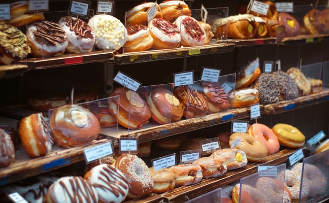 Colorful assortment of donuts on display in a bakery case